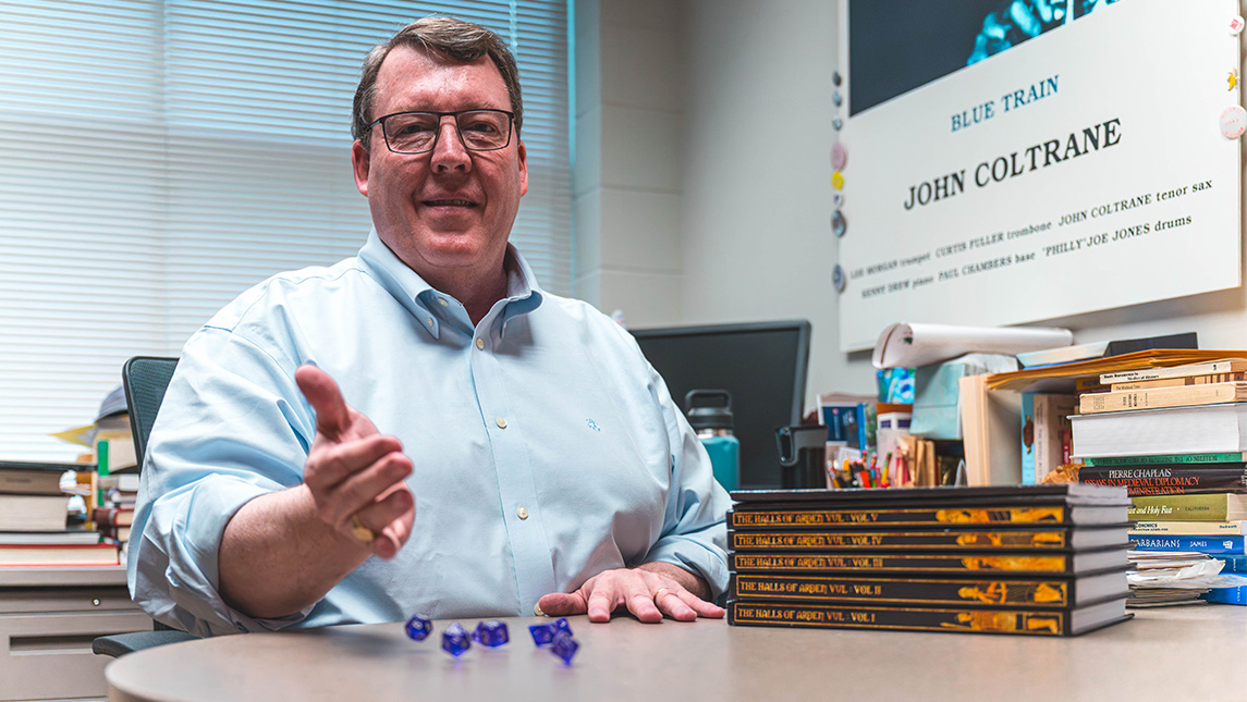 Dr. Rick Barton rolls Dungeons and Dragons dice.